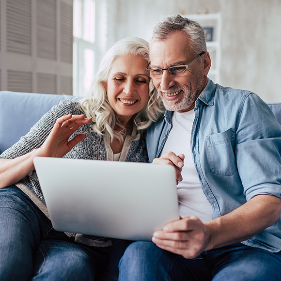 An older couple looking at a laptop