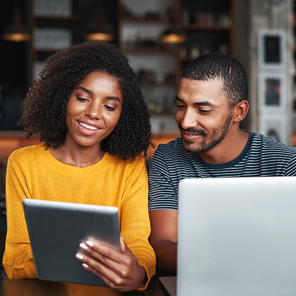 A young couple looking happily at a tablet