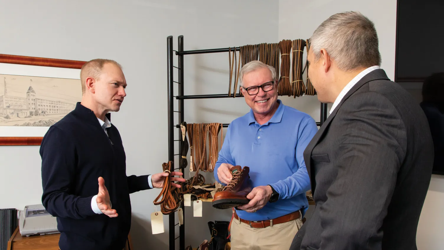 Barbour corporation employees holding shoes and laces and talking to each other 