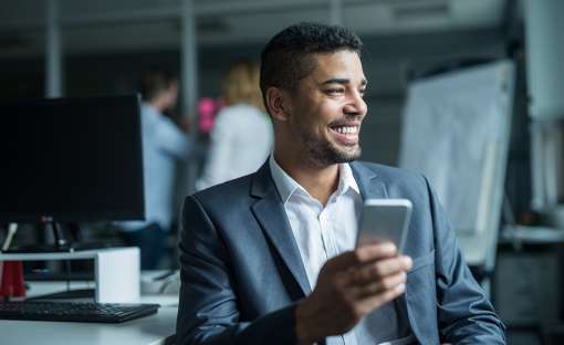 man smiling while using cell phone