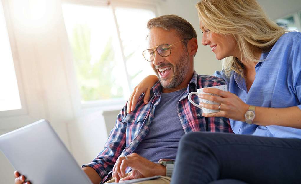 A middle aged couple looking at a laptop