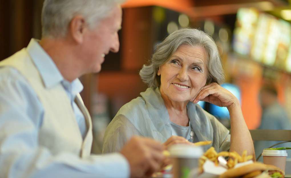 elderly couple enjoying dinner together