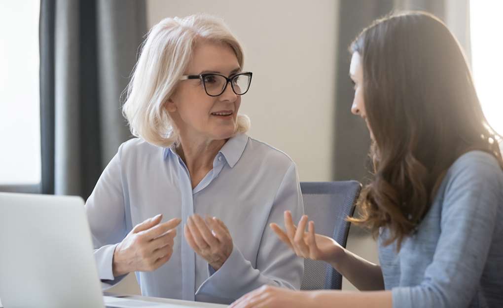 An older woman having a conversation with her daughter