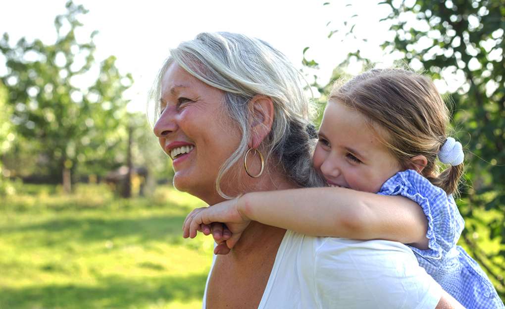 A grandmother gives her granddaughter a piggy-back ride