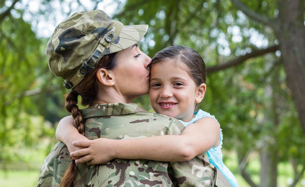 Military woman hugging her daughter