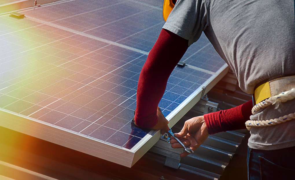 A man installing solar panels.