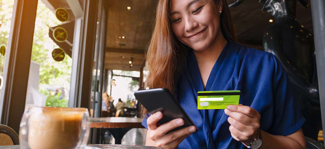 A young woman who is happy to receive her new debit card from North Easton Savings Bank